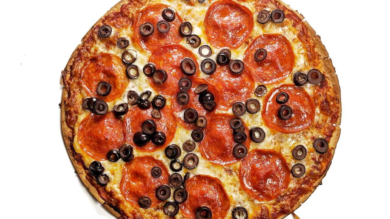 A pizza with pepperoni and black olives